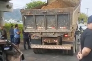 Caminhão caçamba descarrega areia para bloquear rodovia em Ilhota
